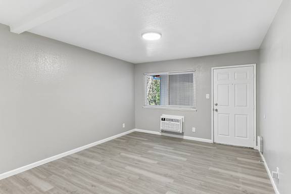 A room with a white door and a window with a plant on the windowsill.