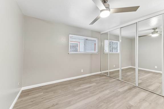 A room with a ceiling fan and mirrored walls.