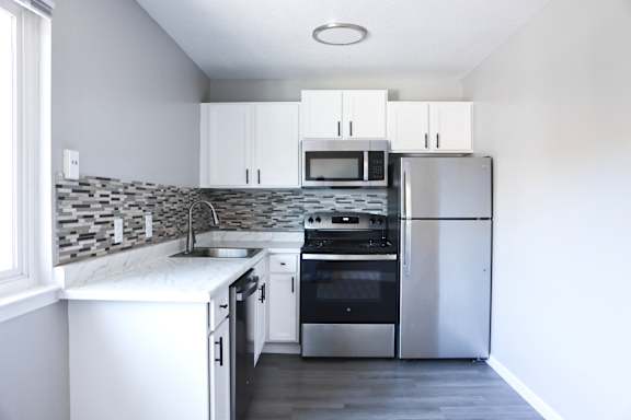 A modern kitchen with stainless steel appliances and white cabinets.