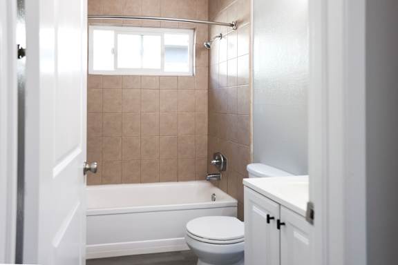 A bathroom with a toilet, sink, and bathtub.