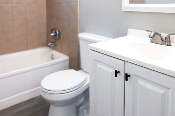 A white toilet sits next to a bathtub in a bathroom.