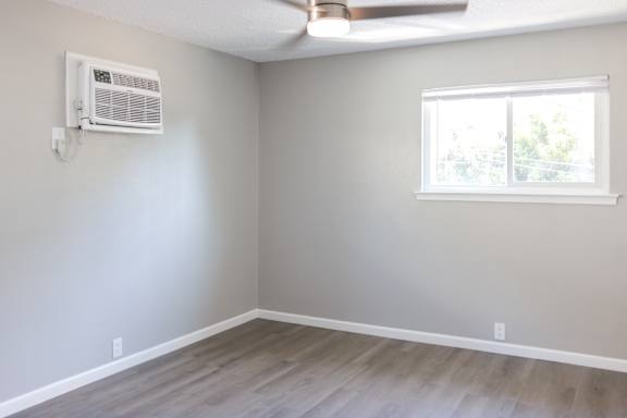 A room with a window and a ceiling fan.