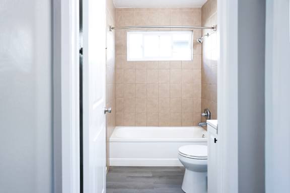 A white toilet sits next to a bathtub in a bathroom.