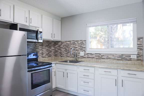 A kitchen with a stove, oven, and sink.