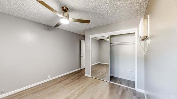 A room with a ceiling fan and a doorway leading to another room at University Square Apartments, Davis