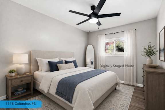 Staged bedroom with neutral bedding and ceiling fan at OSM Properties Homes & Apartments, Chico, California