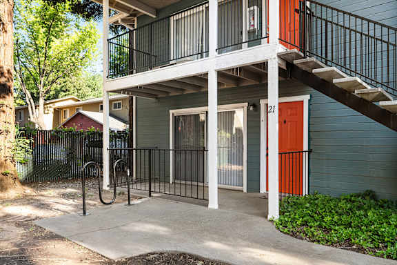 Two story building with exterior stairs and orange door at Redwood Cove Apartments, Chico, 95928
