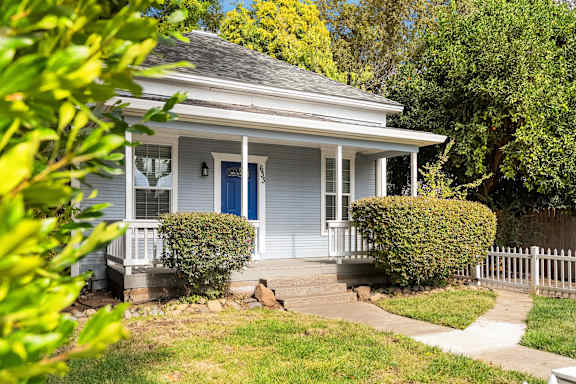 Single story home with blue door and front porch at OSM Properties Homes & Apartments, Chico