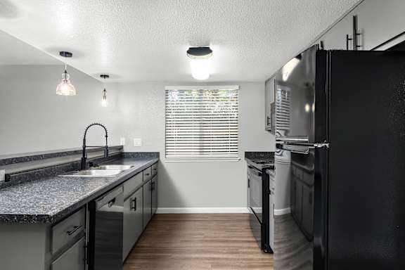 Modern kitchen with island and professional style faucet at Redwood Cove Apartments, Chico