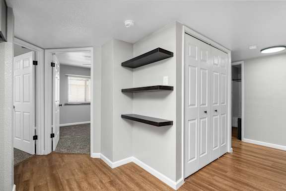 Hallway with floating shelves and closet doors at Redwood Cove Apartments, Chico, California