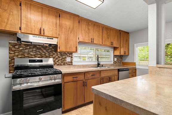 Kitchen with wood cabinets and mosaic tile backsplash at OSM Properties Homes & Apartments, Chico, CA