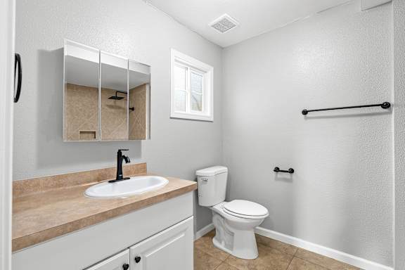 Bathroom with beige countertop and white fixtures at OSM Properties Homes & Apartments, California