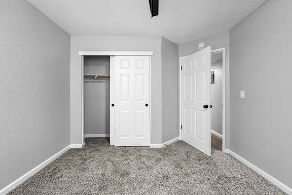 Bedroom with walk-in closet and double doors at Redwood Cove Apartments, California