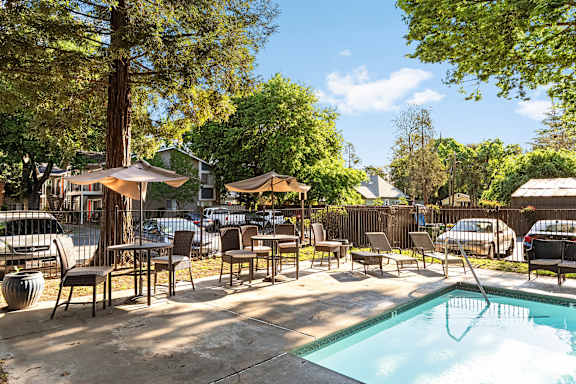 Hot tub with patio seating and umbrellas at Redwood Cove Apartments, Chico, CA 95928
