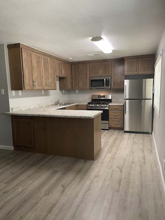Kitchen with wood cabinets and granite island countertop at OSM Properties Homes & Apartments, Chico, CA