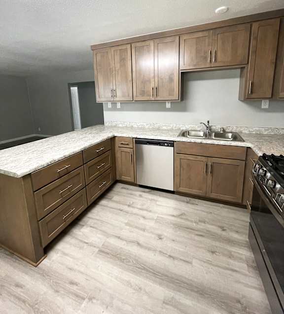 L shaped kitchen with wood cabinets and double sink at OSM Properties Homes & Apartments, Chico, 95926