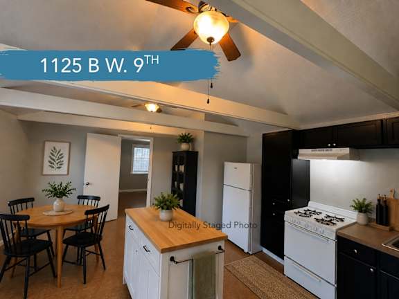 A kitchen with a table and chairs and a ceiling fan.