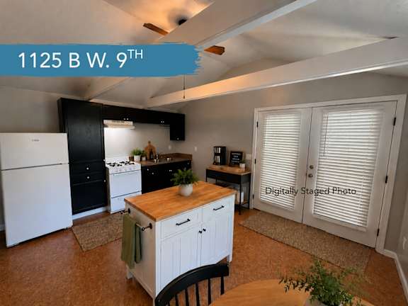 A kitchen with a white fridge and black cabinets.
