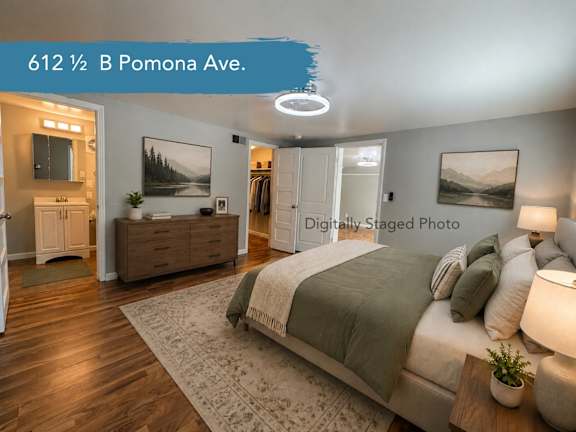 A bedroom with a bed, dresser, and mirror.