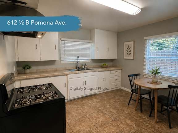 A kitchen with a black stove top oven and white cabinets.