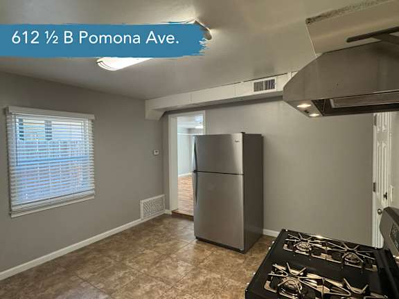A kitchen with a stove top oven and a refrigerator.
