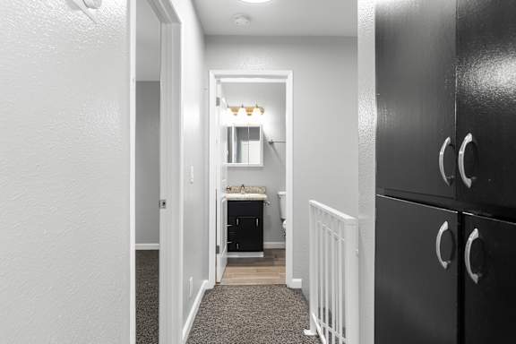 Upstairs hallway with dark wood cabinets and bathroom view at OSM Properties Homes & Apartments, Chico, CA 95926