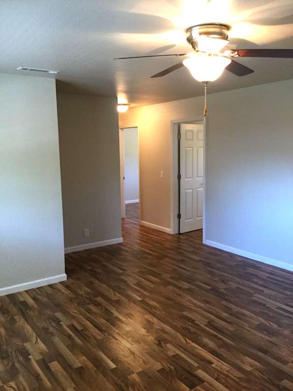 Empty room with ceiling fan and wood flooring at OSM Properties Homes & Apartments, Chico, 95926