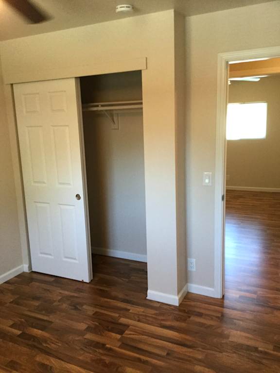 Bedroom with walk-in closet and hardwood floors at OSM Properties Homes & Apartments, Chico, California