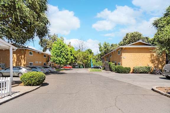 Parking area with apartment buildings and landscaping at OSM Properties Homes & Apartments, California, 95926