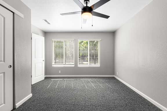 Unfurnished bedroom with carpet and horizontal blinds at OSM Properties Homes & Apartments, Chico, 95926