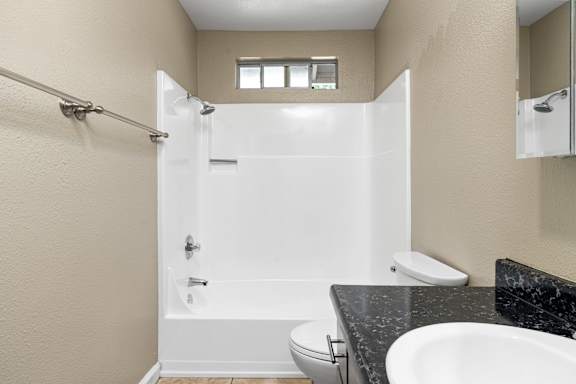 Bathroom with tub shower and toilet at Cedar Park Apartments, Chico, 95926