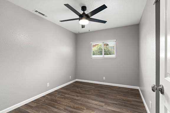 Unfurnished bedroom with ceiling fan and venetian blinds at OSM Properties Homes & Apartments, California