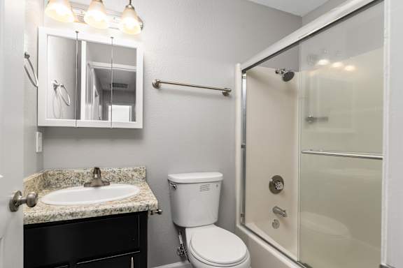 Bathroom with granite countertop and glass tub enclosure at OSM Properties Homes & Apartments, California, 95926