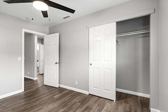 Empty bedroom with open closet and neutral walls at OSM Properties Homes & Apartments, Chico, 95926