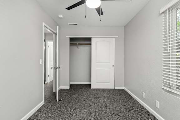 Empty bedroom with open closet and carpeted floor at OSM Properties Homes & Apartments, Chico, California