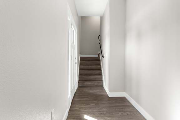 Downstairs entry hall. Stairs leading to the second level. Vinyl plank flooring.
