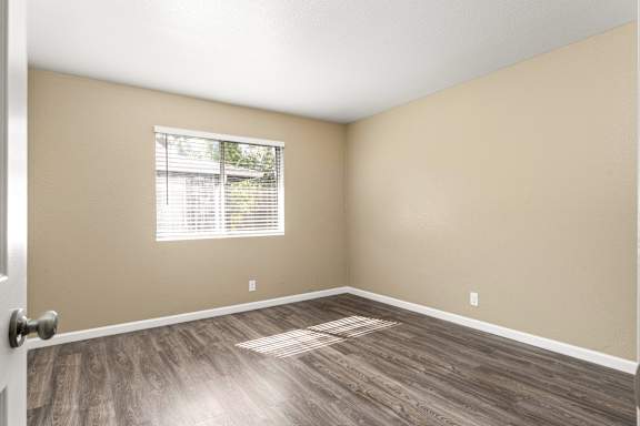 Vacant room with large window and laminate floors at Cedar Park Apartments, Chico, CA 95926
