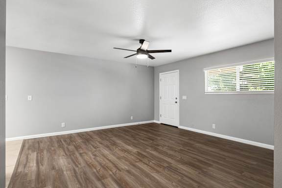 Spacious living room with wood flooring and white door at OSM Properties Homes & Apartments, Chico, CA 95926