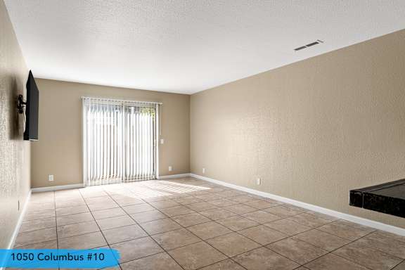 Spacious living area with tile flooring and vertical blinds at Cedar Park Apartments, Chico, 95926