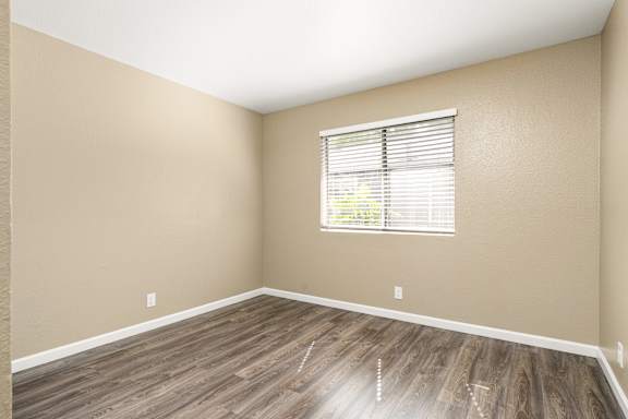 Empty room with window and vinyl plank flooring at Cedar Park Apartments, Chico, California