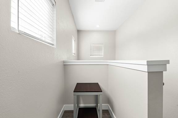 A small table sits in a corner of the upstairs landing by a window.