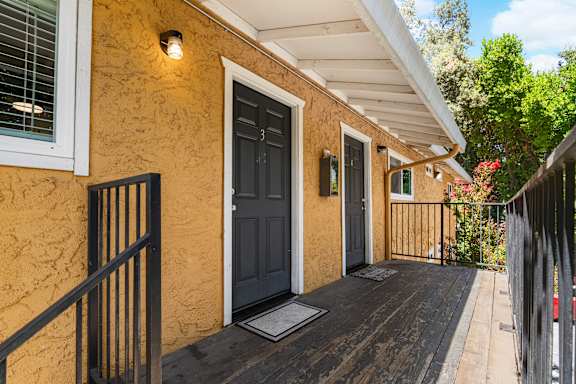 Outdoor walkway with two unit entry doors at OSM Properties Homes & Apartments, Chico