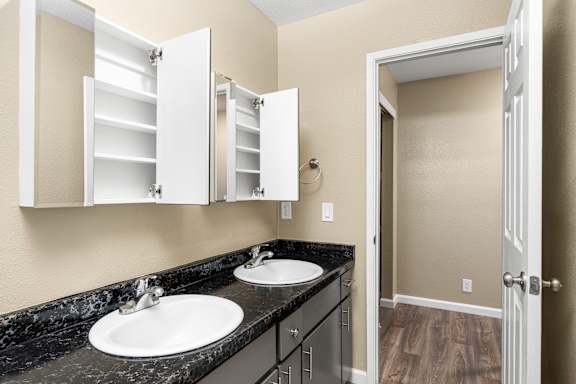 Bathroom vanity with dual sinks and storage cabinets at Cedar Park Apartments, Chico, 95926