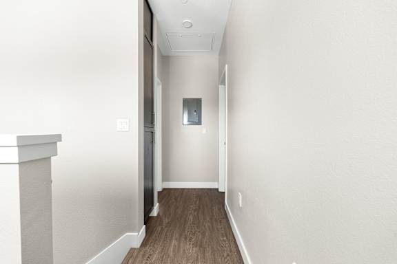 Upstairs hallway leading to third bedroom. Vinyl plank flooring.