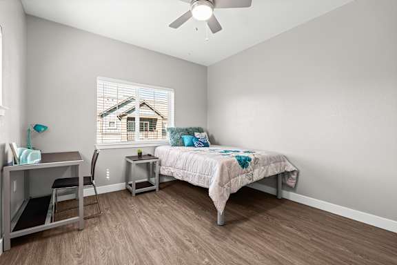 Third bedroom suite upstairs with full size bed, desk, chair, and night stand. Ceiling fan, double window with faux wood blinds. Vinyl plank floors.