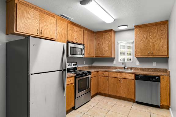 Kitchen with stainless steel appliances and oak cabinetry at OSM Properties Homes & Apartments, California