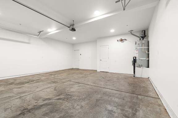 Single car garage with white walls and a concrete floor.