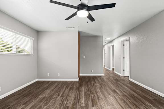 Spacious unfurnished room with ceiling fan and hallway view at OSM Properties Homes & Apartments, Chico, California