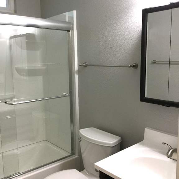 Bathroom with walk-in shower and chrome fixtures at OSM Properties Homes & Apartments, California, 95926