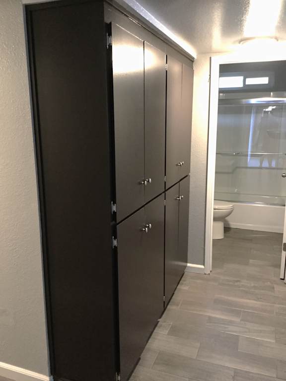 Hallway with dark gray cabinets and bathroom entrance at OSM Properties Homes & Apartments, Chico, CA 95926